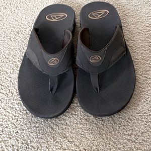 Size 10reef flip flops with beer opener on bottom. NEVER BEEN WORN. Dark Brown